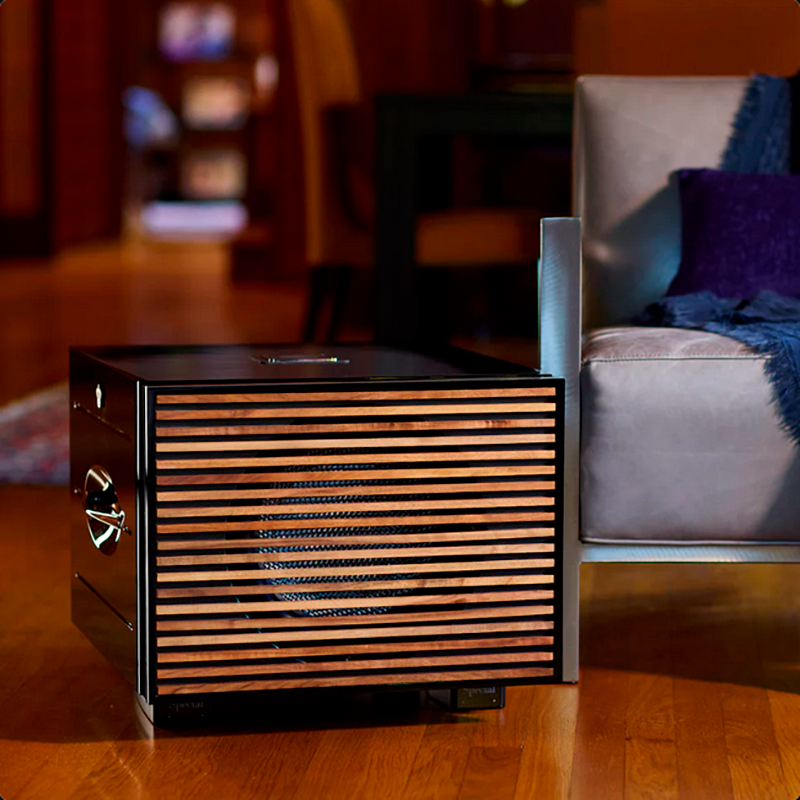 REL Carbon Special Black Label 12" subwoofer premium-puuritilällä olohuoneessa, lifestyle-kuva