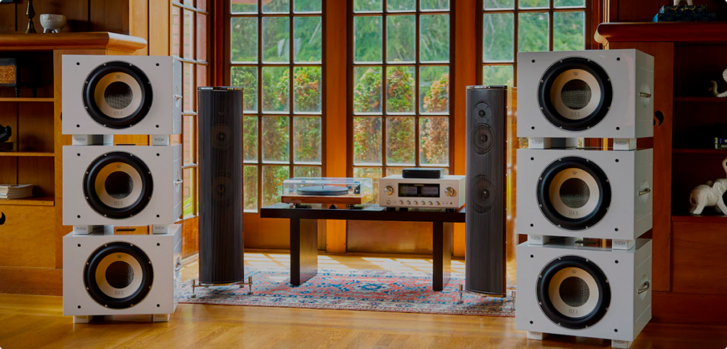 REL S/850 valkoinen line array -kokoonpano, kolme subwooferia vasemmalla ja oikealla