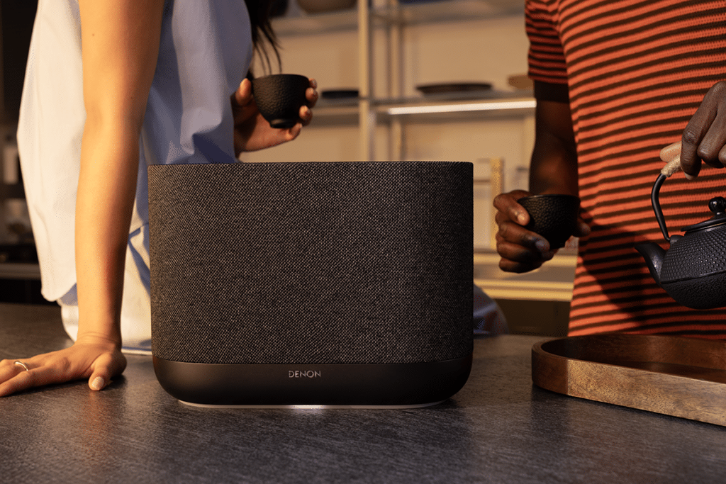 Denon Home 400 on langaton HEOS-monihuonekaiutin, joka on suunniteltu yhtä tavoitetta varten: yksi kaiutin, joka kuulostaa isolta. Se ei yritä olla minikokoinen, vaan tarkoituksella riittävän kokoinen ja rakenteeltaan riittävän vahva, jotta se pystyy täyttämään olohuoneen tai avaramman keittiö–olohuone-tilan ilman, että ääni jää “pieneksi”. Kun musiikki ansaitsee enemmän kuin taustasoiton, Home 400 on se malli, joka nostaa mittakaavan heti oikealle tasolle. Dolby Atmos Music on Home 400:n selkeä erottaja. Kahden ylöspäin suuntautuvan elementin idea ei ole “efektipuhetta”, vaan käytännön tapa kasvattaa äänikuvan korkeutta ja tilantuntua: ääni heijastuu huoneesta ja tuntuu ympäröivämmältä kuin perinteisessä yhden rungon kaiuttimessa. HEOS on samalla järjestelmän selkäranka. Se tarkoittaa, että Home 400 toimii yksinään vahvana pääkaiuttimena, mutta myös osana isompaa kokonaisuutta: lisäät kaiuttimia, ryhmittelet huoneisiin, tai rakennat kahdesta Home 400:sta langattoman stereoparin, jolloin äänikuva levenee selvästi ja kokonaisuus rauhoittuu. Lifestyle-moduuli (kuvan rinnalle): Denon Home 400 on tehty arkeen niin, että se voi olla näkyvällä paikalla ja silti “soida isosti”. Se sopii sivutasolle tai keittiö–olohuone-alueen keskipisteeksi, kun haluat enemmän läsnäoloa kuin kompaktimmista malleista. HEOS-ohjaus pitää käytön kevyenä: musiikki käyntiin, ryhmittely huoneisiin ja hallinta sovelluksella. Kun kokonaisuus kasvaa, Home 400 istuu luontevasti monihuonetoiston vahvaksi tukipilariksi – ja kahdesta kaiuttimesta saat langattoman stereoparin, joka tekee kuuntelusta selvästi “oikeamman” stereon.